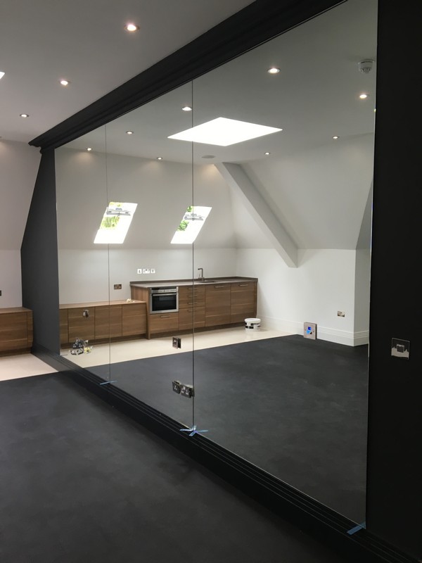 Frameless glass partition in loft conversion by Enfield glaziers