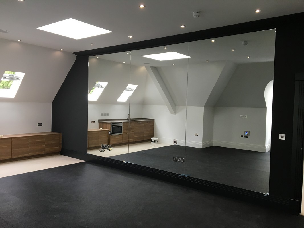 Frameless glass wall dividing loft conversion in Enfield