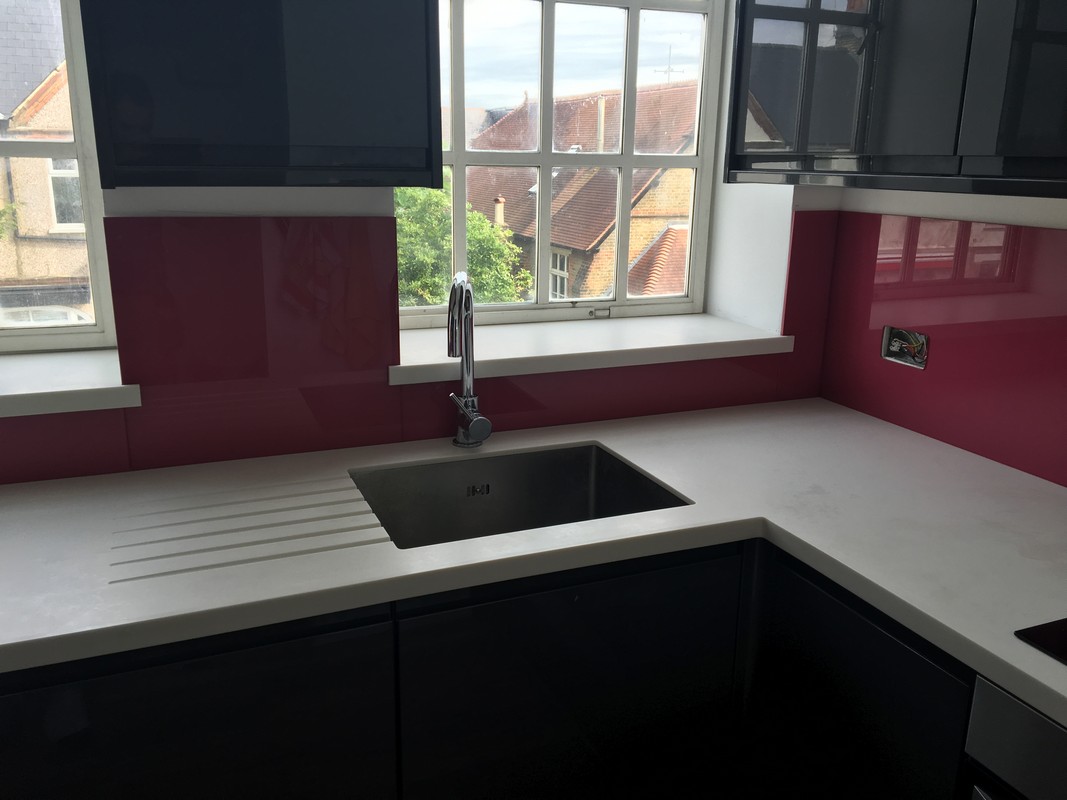 Deep plum coloured glass splashback in modern Enfield kitchen